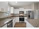 Bright kitchen features stainless steel appliances, granite countertops, and ample white cabinetry, perfect for culinary enthusiasts at 174 Pine Crse, Ocala, FL 34472
