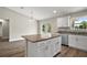 Modern kitchen island boasts granite countertops and sleek white cabinetry, creating an inviting cooking space at 174 Pine Crse, Ocala, FL 34472