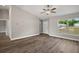 Bright living room featuring a large window, ceiling fan, wood-look flooring, and a view of the outdoors at 174 Pine Crse, Ocala, FL 34472