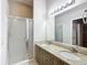 Bathroom boasts double sinks, granite counters, and a shower at 2117 Sansores St, The Villages, FL 32159