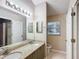 Double vanity bathroom with granite countertops and a shower at 2117 Sansores St, The Villages, FL 32159