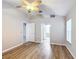Bright bedroom with wood-look floors, ceiling fan, and access to bathroom at 2117 Sansores St, The Villages, FL 32159