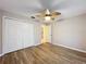 Bedroom with wood-look floors, ceiling fan, and access to bathroom at 2117 Sansores St, The Villages, FL 32159