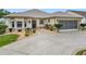 Tan house with screened garage and manicured landscaping at 2117 Sansores St, Lady Lake, FL 32159