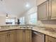 Kitchen with granite countertops, stainless steel sink, and view into dining area at 2117 Sansores St, The Villages, FL 32159