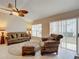 Relaxing living room with a sofa, armchair, and sliding glass door leading outdoors at 2117 Sansores St, The Villages, FL 32159