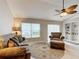 Cozy living room featuring a comfy sofa, armchair, ottoman, and built-in shelving at 2117 Sansores St, The Villages, FL 32159