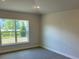 Bright bedroom with a large window overlooking the outdoor landscape and plush carpeting at 2134 Nw 23Rd Loop, Ocala, FL 34475