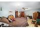 Cozy bedroom with wood-look floors, a ceiling fan, and natural light at 10249 Nw 21St St, Ocala, FL 34482