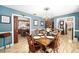 Traditional dining room with wood floors, a formal dining table set for dinner, and blue painted walls at 10249 Nw 21St St, Ocala, FL 34482