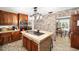 Kitchen with brick accent wall, island, and wood cabinets at 10249 Nw 21St St, Ocala, FL 34482