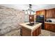 Kitchen with brick accent wall, island, and wood cabinets at 10249 Nw 21St St, Ocala, FL 34482