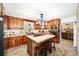 Kitchen with brick accent wall, island, and wood cabinets at 10249 Nw 21St St, Ocala, FL 34482