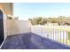 This outdoor balcony features a gray tile floor and a white railing overlooking the fenced yard at 11001 Se Sunset Harbor Rd # F45, Summerfield, FL 34491