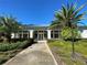 Inviting clubhouse entrance with lush landscaping and beautiful architectural details and blue metal roof at 11147 Sw 68Th Ct, Ocala, FL 34476