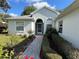 Inviting entrance with brick walkway, beautiful flower beds and manicured hedges leading to the front door at 11147 Sw 68Th Ct, Ocala, FL 34476