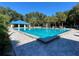 Sparkling pool view with ample lounge seating, clear blue water, and palm tree landscaping at 11147 Sw 68Th Ct, Ocala, FL 34476