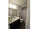 Clean bathroom with dark vanity and marble shower surround at 12495 Se 102Nd Ave, Belleview, FL 34420