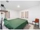 Spacious bedroom with green bedding, two windows, and a leather chair at 217 Nw 14Th St, Ocala, FL 34475