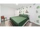 Main bedroom with green bedding and a tropical-themed accent wall at 217 Nw 14Th St, Ocala, FL 34475