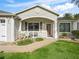 Tan house with white porch and landscaping at 2360 Hopespring Loop, The Villages, FL 32162