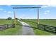 Long driveway entrance with wooden gate leading to a country home at 4027 N C 470, Lake Panasoffkee, FL 33538