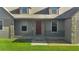 Covered front porch with stone accents and red door at 4027 N C 470, Lake Panasoffkee, FL 33538