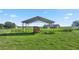 Metal-frame storage shed with a rusty horse trailer, set against a rural backdrop at 4027 N C 470, Lake Panasoffkee, FL 33538