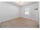 Bright bedroom with neutral carpet, white walls, modern lighting, and a window with blinds at 4812 Se 37Th St, Ocala, FL 34480