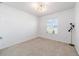 Bright bedroom featuring neutral carpet, white walls, modern lighting and natural light from the window at 4812 Se 37Th St, Ocala, FL 34480