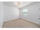 Bedroom featuring neutral carpet, white walls, modern lighting, and a window with blinds at 4812 Se 37Th St, Ocala, FL 34480