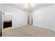 This bedroom features neutral carpet, white walls, stylish lighting, and an open doorway to the bathroom at 4812 Se 37Th St, Ocala, FL 34480