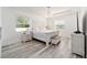 Bright main bedroom with white furniture, wood floors, tray ceiling, and two windows at 4812 Se 37Th St, Ocala, FL 34480