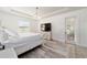 Well-lit main bedroom featuring wood floors, a tray ceiling, and a glass door to the outside at 4812 Se 37Th St, Ocala, FL 34480