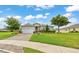 Charming single-story home featuring a well-manicured lawn, brick driveway, and tasteful landscaping under a blue sky at 6407 Sw 45Th Ave, Ocala, FL 34474