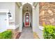 Inviting front entrance with a red door, stone accents, and manicured landscaping creating curb appeal at 6407 Sw 45Th Ave, Ocala, FL 34474