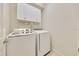 Bright laundry area with overhead storage and modern appliances at 6407 Sw 45Th Ave, Ocala, FL 34474