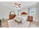 Stylish main bedroom showcasing a ceiling fan, natural light, and a comfortable seating area perfect for relaxation at 6407 Sw 45Th Ave, Ocala, FL 34474