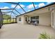 Relaxing screened-in patio featuring neutral concrete floors, ceiling fan, and a seating area at 6407 Sw 45Th Ave, Ocala, FL 34474