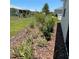 Landscaped backyard featuring lush lawn and decorative mulch beds filled with a variety of plants and greenery at 7682 Sw 89Th Ct, Ocala, FL 34481