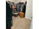 This walk-in closet features ample shelving, a place to sit, and a wicker hamper at 7682 Sw 89Th Ct, Ocala, FL 34481