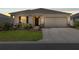 Exterior shot of a charming single-story house with a well-maintained lawn and a two-car garage at dusk at 7682 Sw 89Th Ct, Ocala, FL 34481