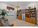 Inviting sitting room with neutral carpet, wicker furniture, plants, and wooden bookshelves at 7682 Sw 89Th Ct, Ocala, FL 34481
