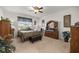 Cozy main bedroom with a ceiling fan, neutral walls, and ample natural light from a large window at 7682 Sw 89Th Ct, Ocala, FL 34481