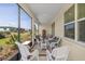 Cozy screened porch with white wicker furniture, perfect for outdoor relaxation at 7682 Sw 89Th Ct, Ocala, FL 34481