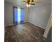 Bedroom with blue curtains, wood-look flooring, and neutral walls at 113 Guava Ter, Ocklawaha, FL 32179