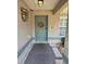 Close-up of the front door with a decorative wreath and a welcoming entrance to the home at 113 Guava Ter, Ocklawaha, FL 32179