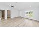 Living room with vinyl flooring, large window, and access to laundry and bath at 127 Marion Oaks Golf Way, Ocala, FL 34473