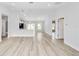 Bright living room with light walls and vinyl flooring, open to kitchen area at 127 Marion Oaks Golf Way, Ocala, FL 34473