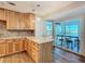 Kitchen with wood cabinets, marble island, and view of the patio at 21343 Sw Plantation St, Dunnellon, FL 34431